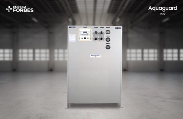 Grey industrial water purifier cabinet with control panel and gauges, Aquaguard Pro branding, in a spacious warehouse.